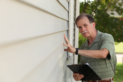 Adult male inspects siding